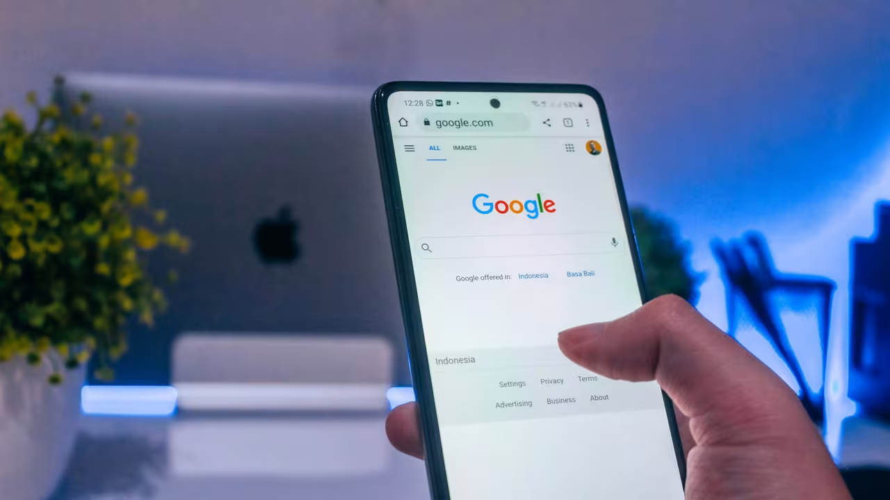 Une personne consulte Google sur son smartphone (photo Arkan Perdana / Unsplash)